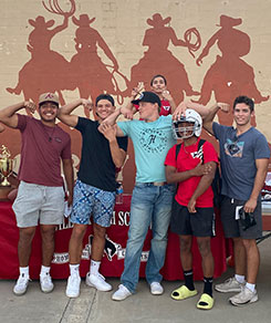 Senior boys posing in front of cowboy mural