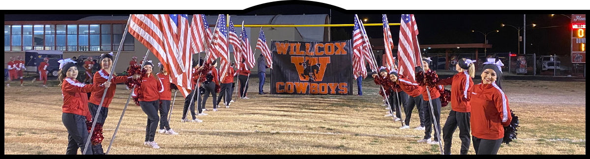 Cheerleaders holding American flags for the football team run in
