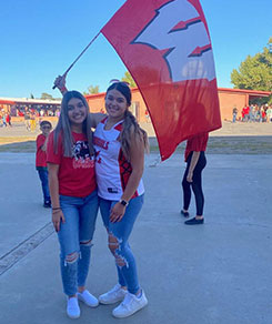 Girls holding Willcox High flag in the courtyard